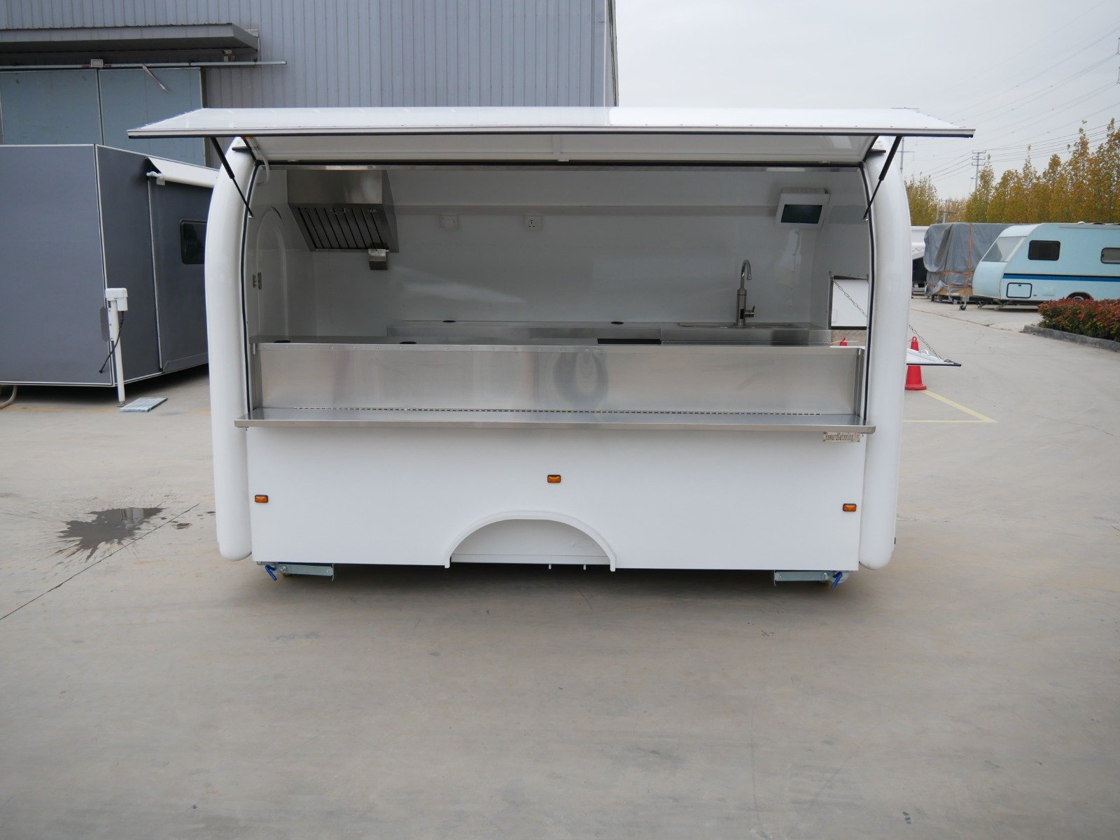 open white food trailer parked in an outdoor lot.